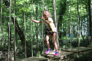 Petite fille sur un parcours accrobranche au Parc Aventure de Fontdouce entre Cognac et Saintes